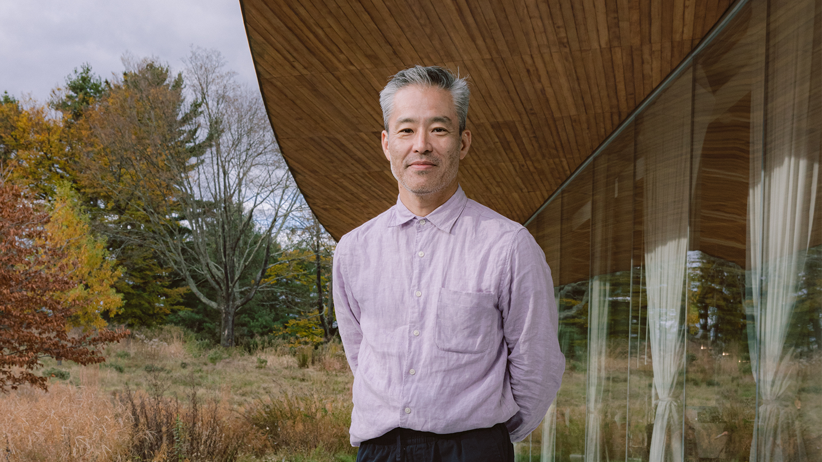 Architect Toshihiro Oki standing in front of the River building at Grace Farms