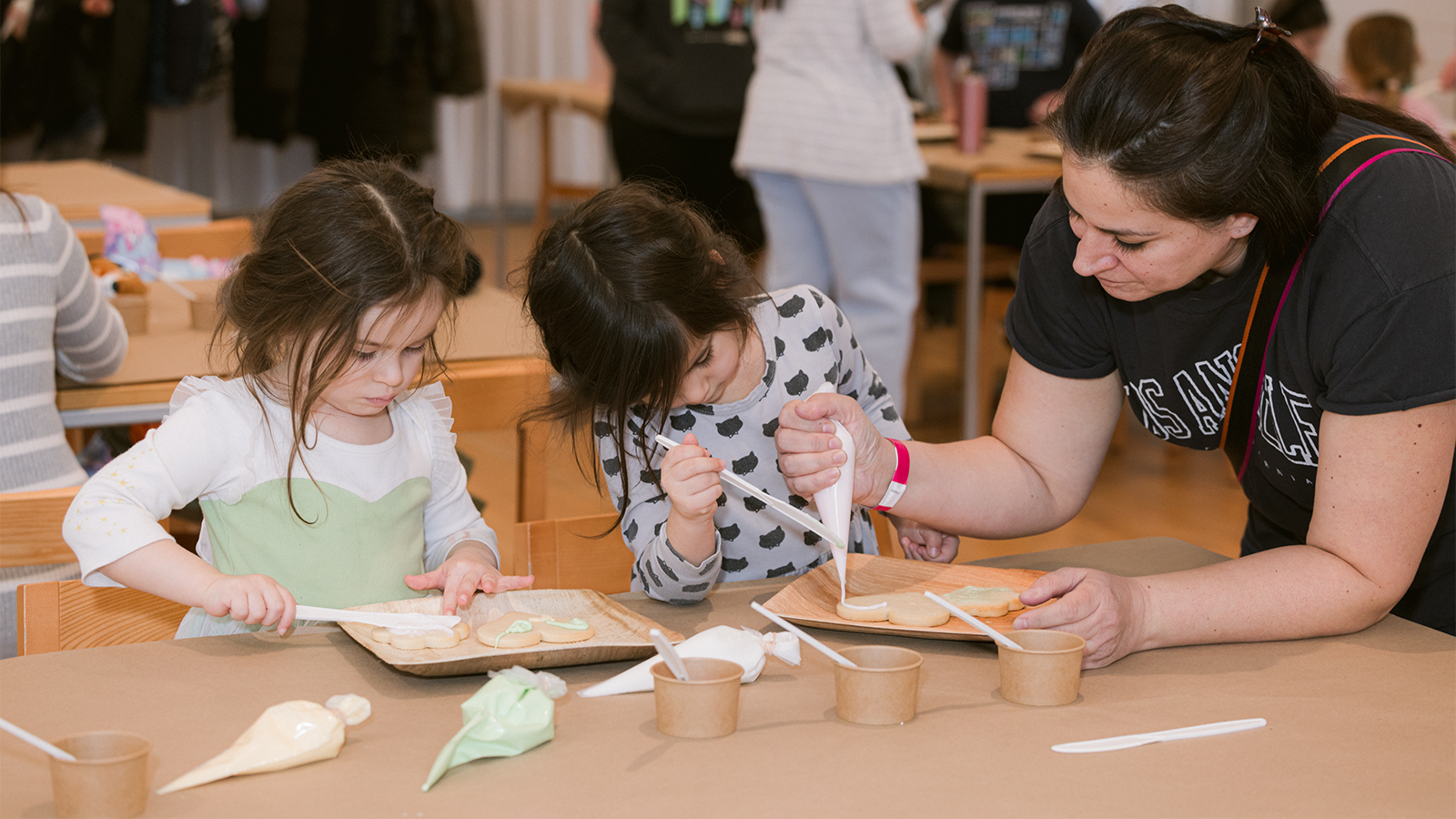 Children decorate sugar cookies with families.